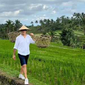 Dr. Göksel walking through rice fields during a cultural trip in Asia.